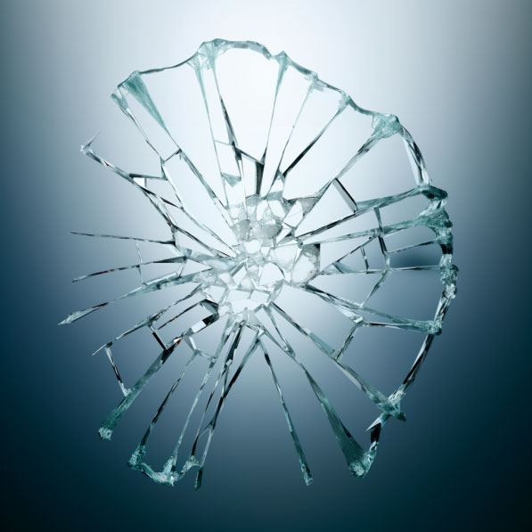 Nahaufnahme eines kreisförmig zerbrochenen Glases, welches Fragilität und Verletzlichkeit symbolisiert